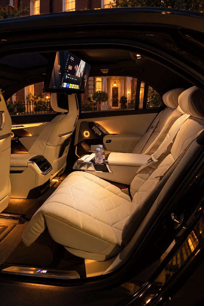 Rear seats of the BMW 7 Series at dusk, cream leather and rear screen